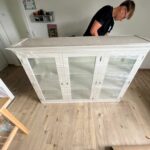 Mitarbeiter von Möbeltaxi Lüneburg prüft die Folierung eines Möbelstücks